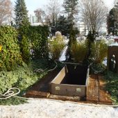 Grabstätte mit grüner Grabdekoration für die Beisetzung