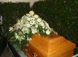 Sarggebinde in Weiß mit Lilien, Rosen und Gerbera