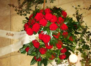 Trauergesteck mit roten Rosen und Schleifenband