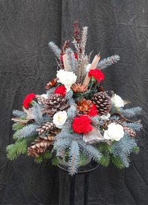 Trauergesteck winterlich mit roten Nelken und weißen Rosen