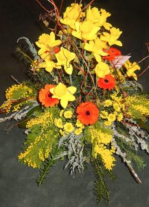 Trauergesteck mit gelben Narzissen und orangenen Gerbera