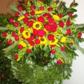 Trauerkranz mit roten Rosen und Sonnenblumen