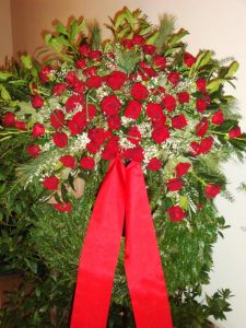 Trauerkranz mit roten Rosen, weißem Ginster und Schleifenband