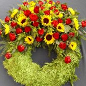 Trauerkranz mit roten Rosen und Sonnenblumen
