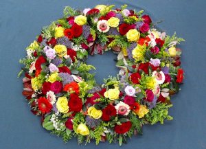 Rundgesteckter Trauerkranz mit Rosen und Gerbera