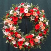 Trauerkranz rund gesteckt in Rot, Orange und Creme