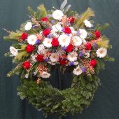 Trauerkranz mit weißen Gerbera, roten Rosen und blauen Perlhyazinthen