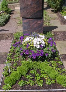 Einzelwahlgrab im Sommer mit bunter Schale