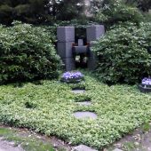 Familiengrab mit Dauergrün und Schalen im Frühling