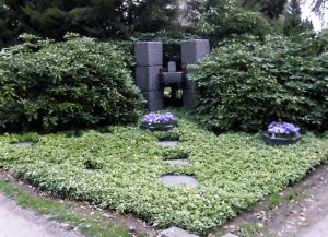 Familiengrab mit Dauergrün und Schalen im Frühling