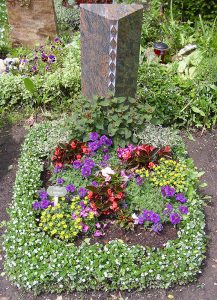 Bunt bepflanztes Urnengrab